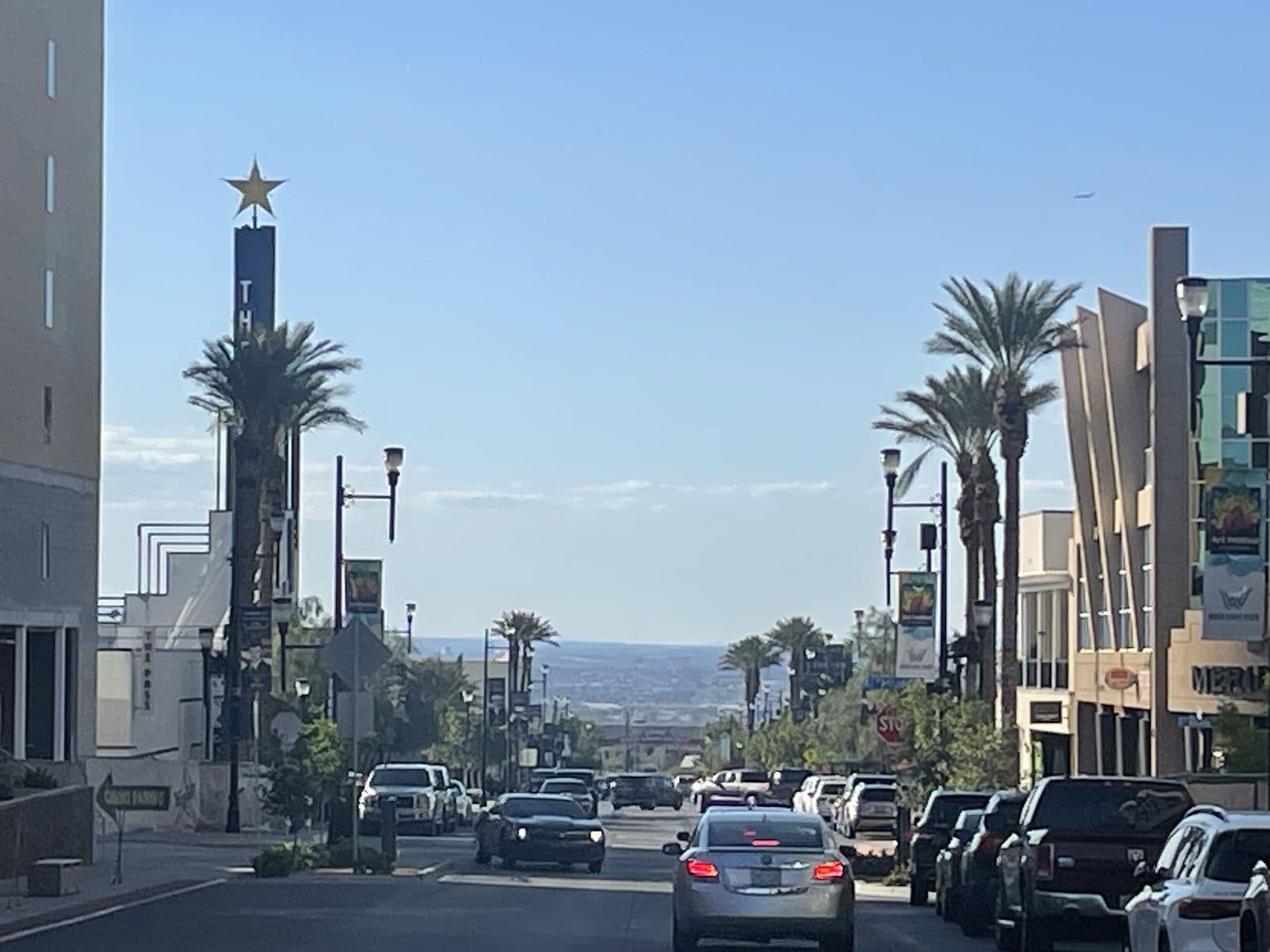 Water Street in downtown Henderson: a palm-lined street sloping toward the Las Vegas Valley, with a star-topped casino marquee, streetlamps and mid-century storefronts