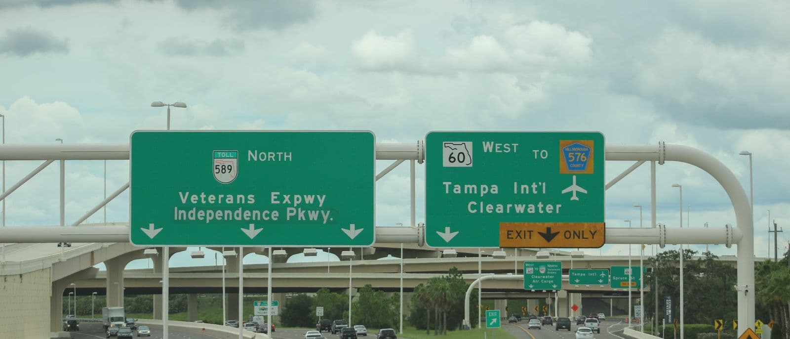 Green overhead signs near Tampa International Airport: State Road 589 north for the Veterans Expressway, and an exit-only lane for State Road 60 west to the airport and Clearwater